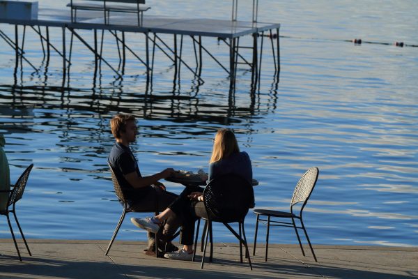 Couple at table enjoys food and drink by Lake Mendota at Memorial Union, University of Wisconsin, Madison, Wisconsin.